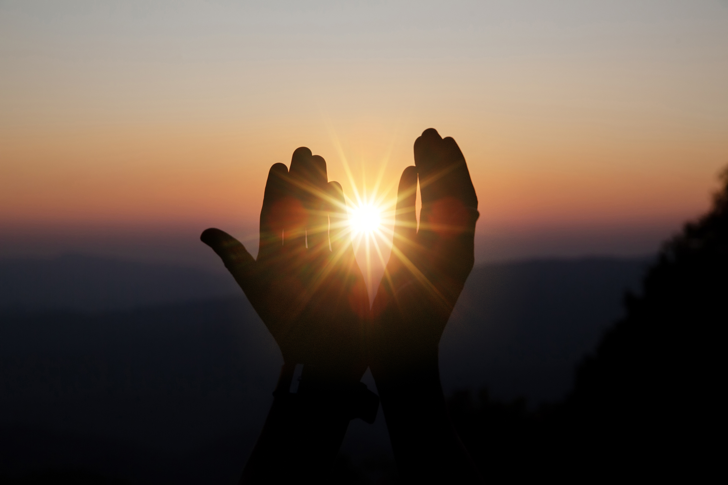 Praying hands raised in faith