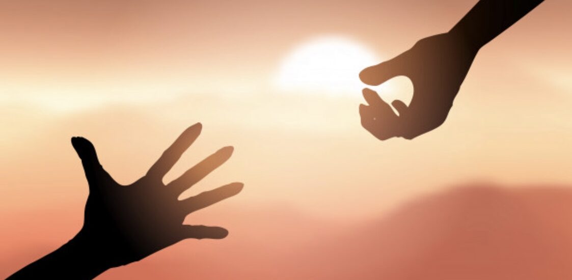 Hands reaching upward at sunset