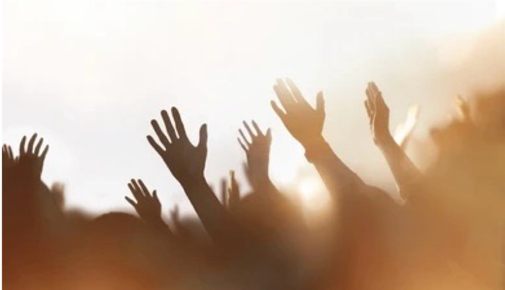 raised hands in worship with glowing light