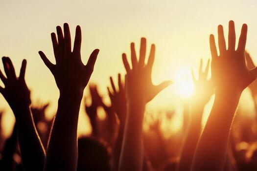 Hands raised in worship at sunrise